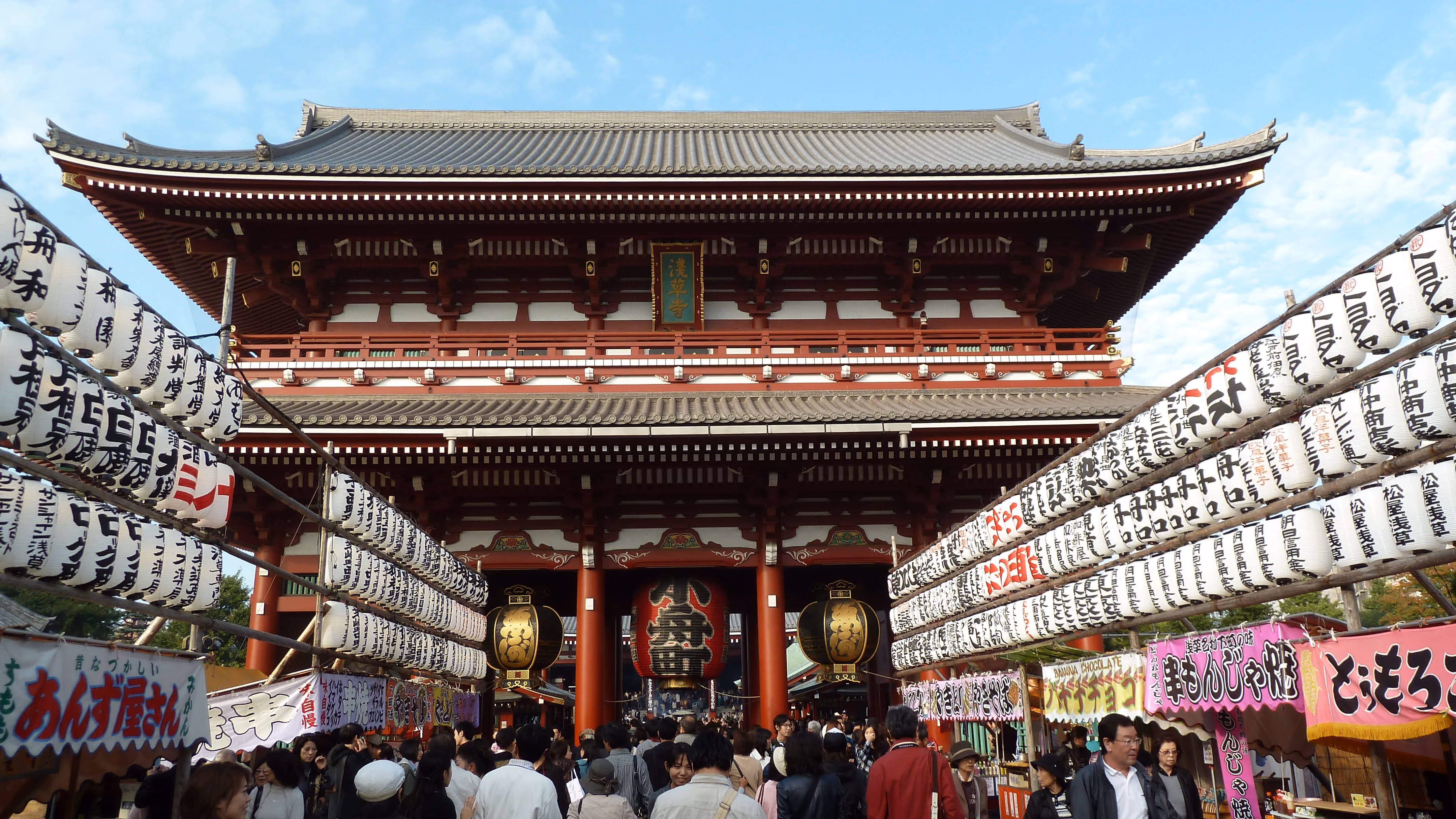 Kaminarimon, the red lantern gate at the entrance to Senso-ji, seen above a crowded Nakamise-dori