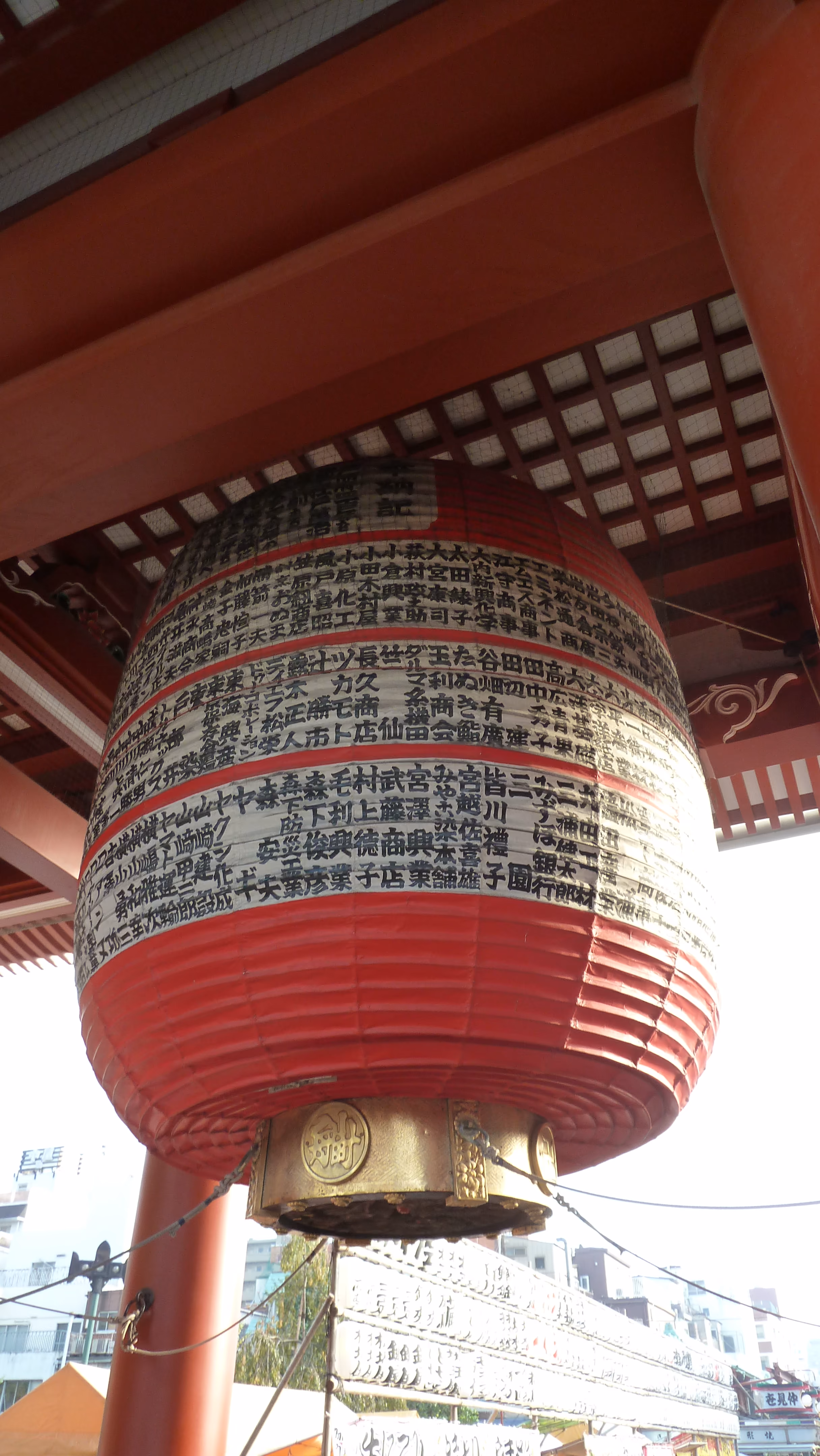 Close-up of a temple lantern's fabric panel, printed with columns of donor names