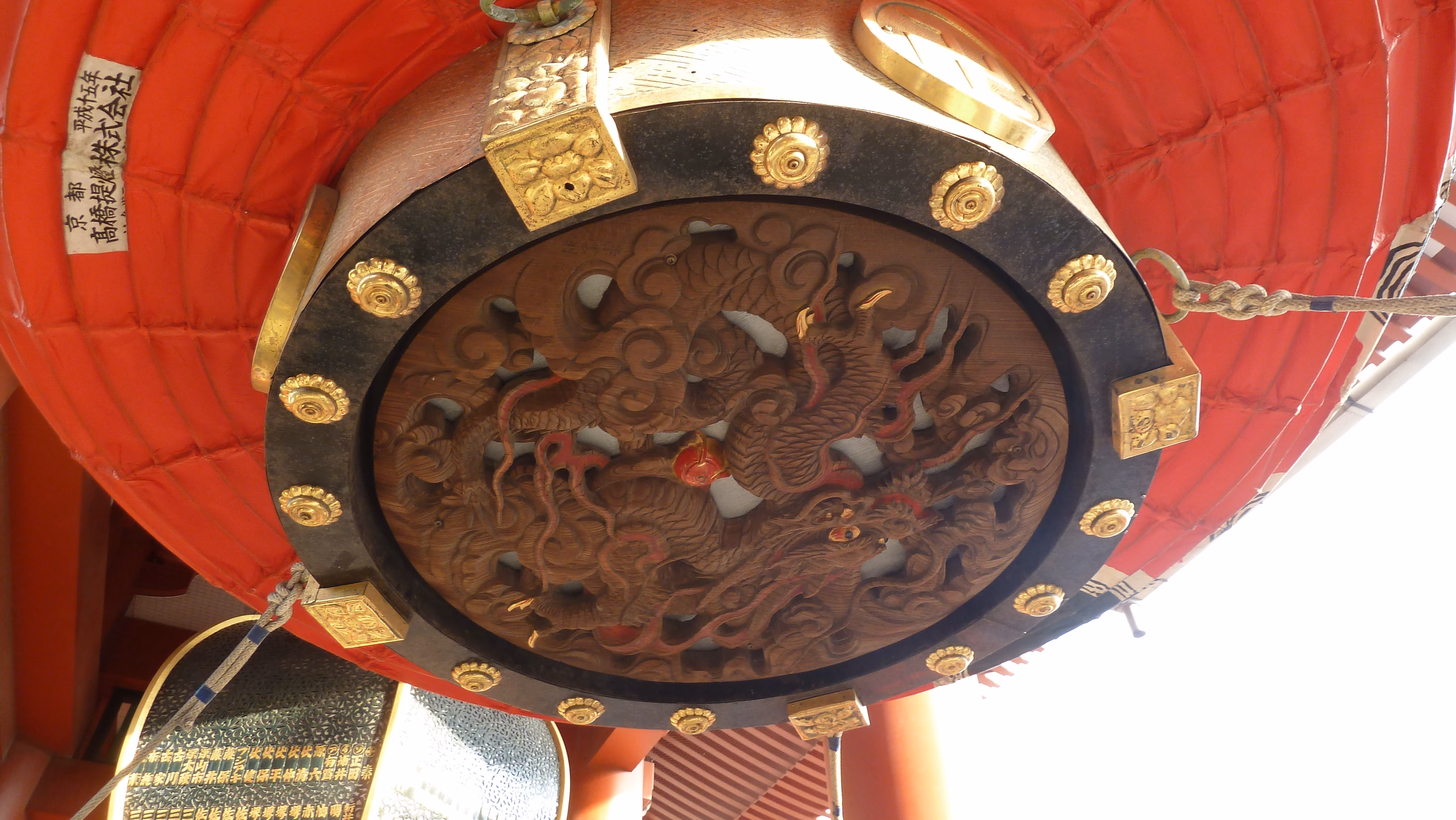 View looking straight up at the underside of a lantern, showing a carved wooden dragon relief