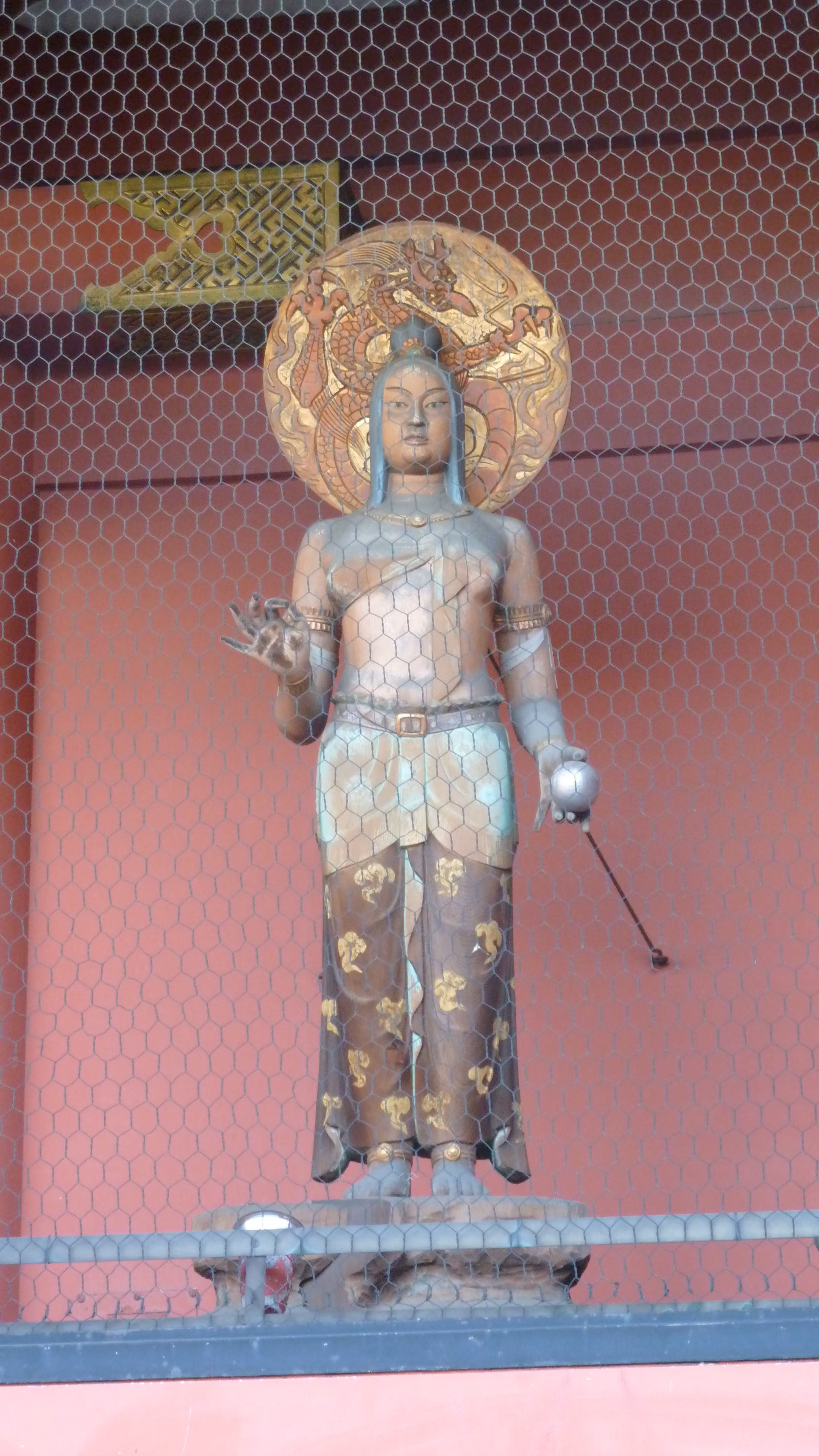 Guardian statue at Hōzōmon, photographed through protective wire mesh