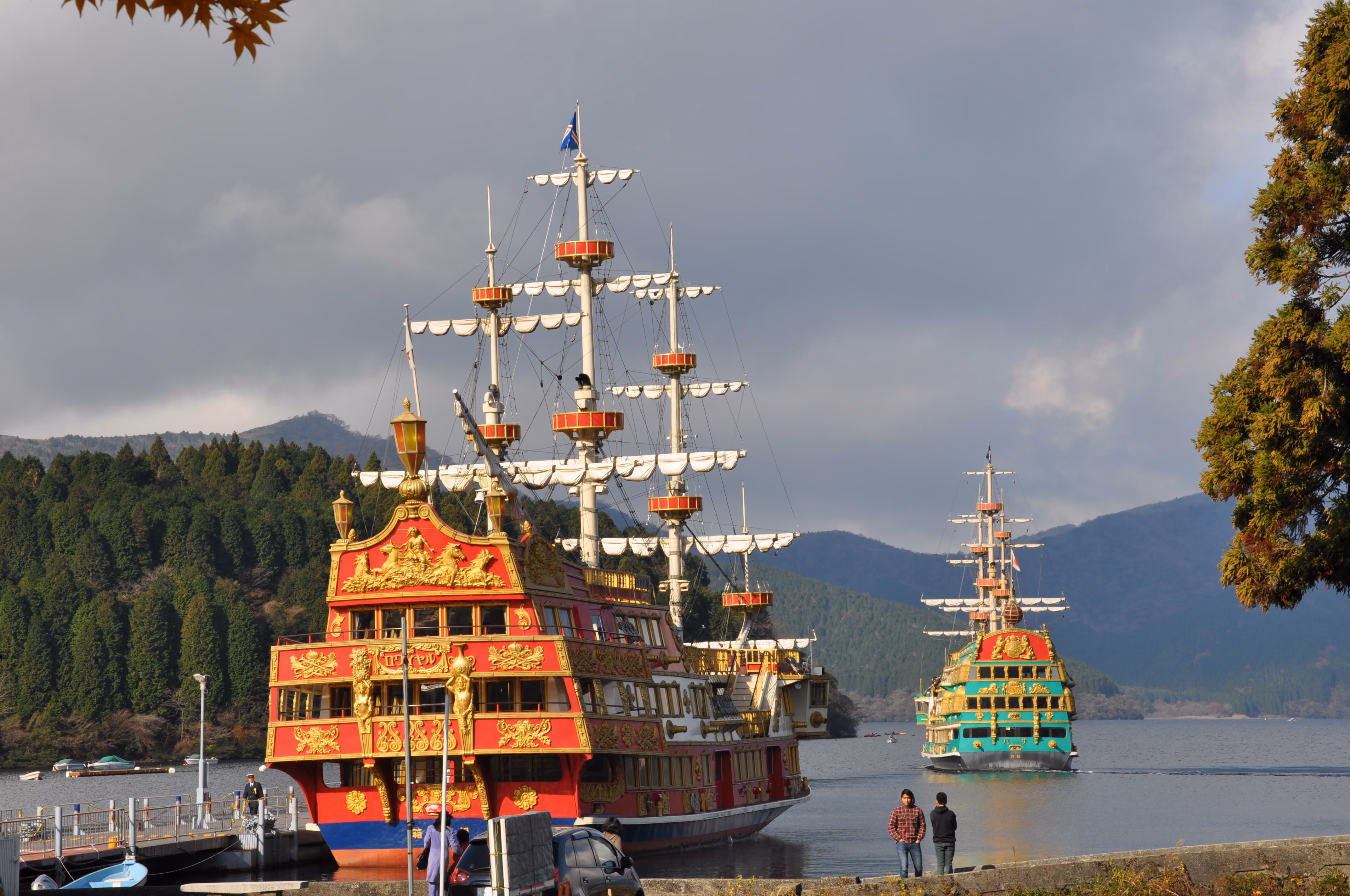 A pirate-ship-styled tourist boat docked at Lake Ashi with mountains behind it