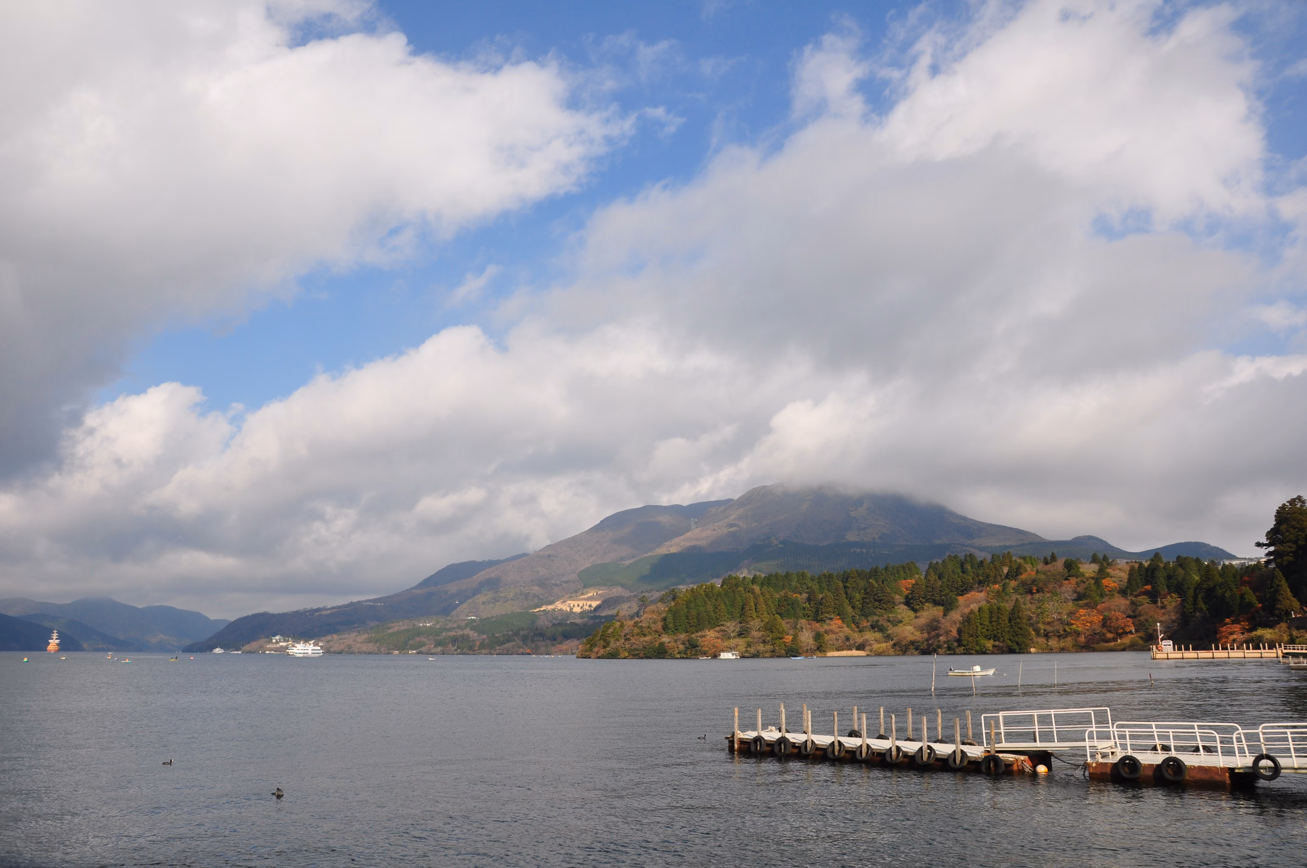 Wide view of Lake Ashi with a mountain partially covered in cloud