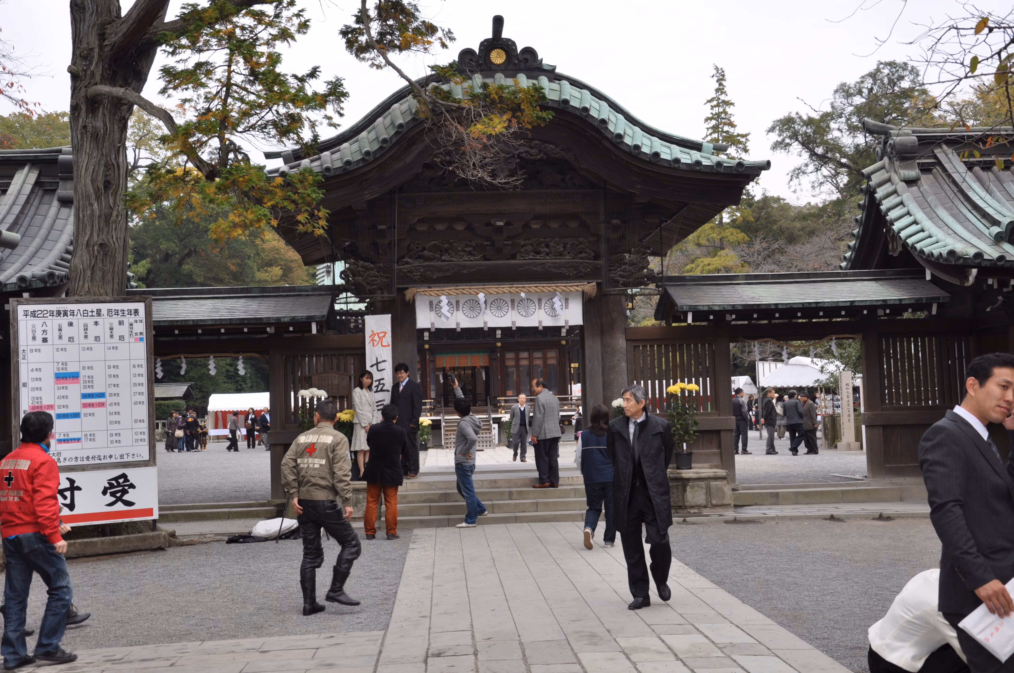 Visitors at the Shinmon gate of Mishima Taisha, with a Shichi-Go-San banner hanging inside