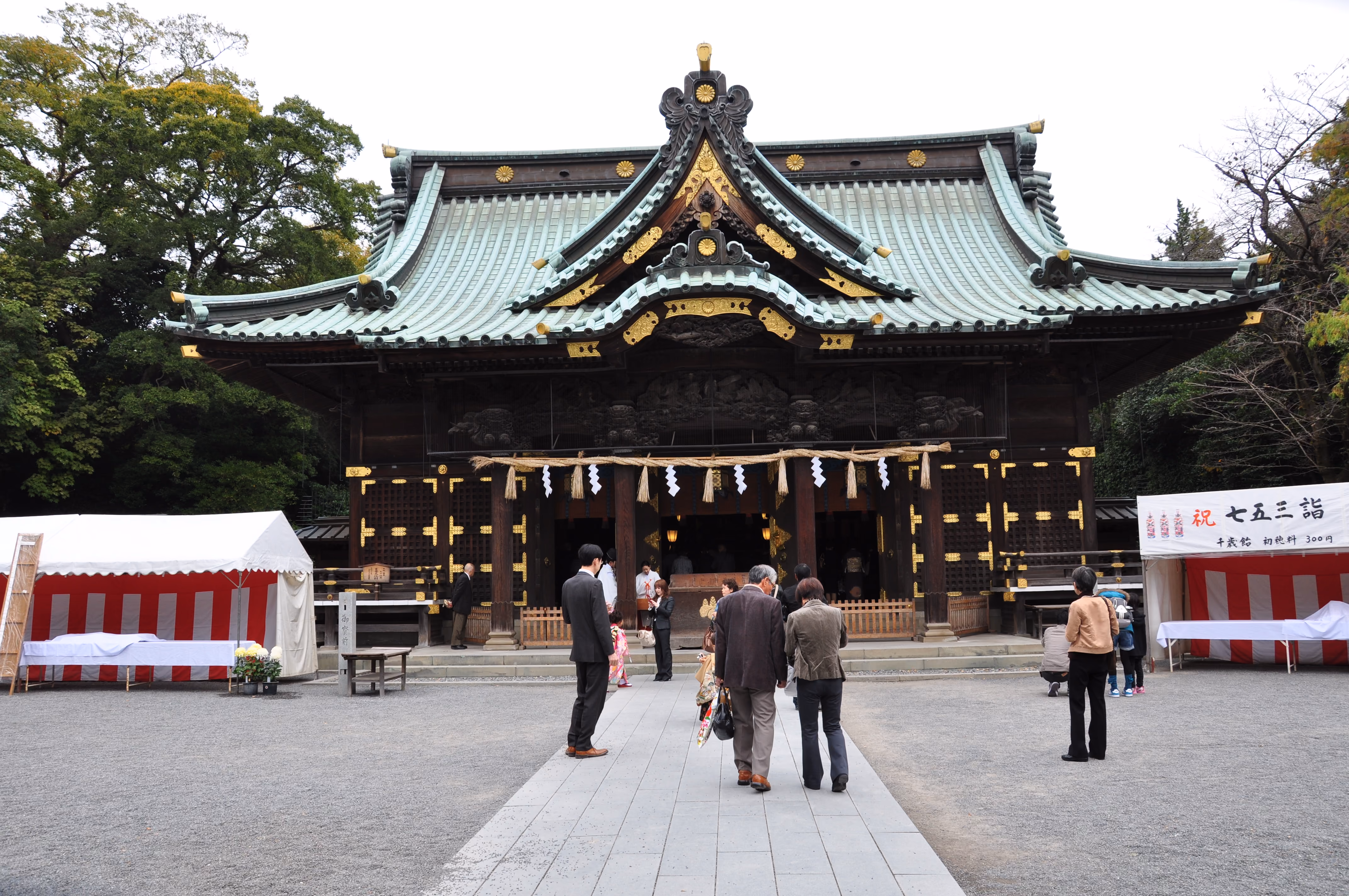 Front view of Mishima Taisha's main hall with a thick shimenawa rope and a Shichi-Go-San banner tent to the side