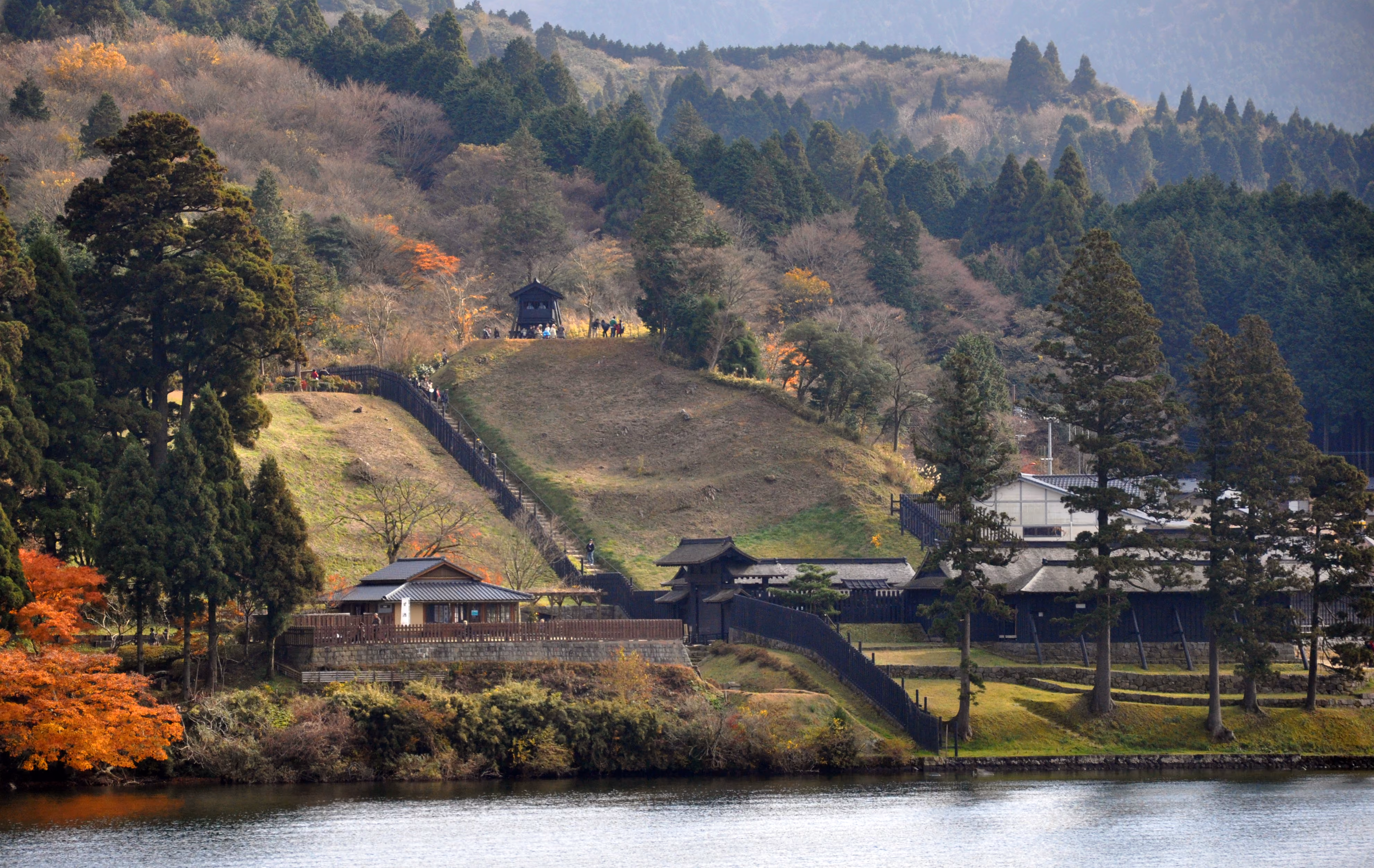 The reconstructed Edo-period Hakone checkpoint buildings seen across Lake Ashi, surrounded by autumn foliage