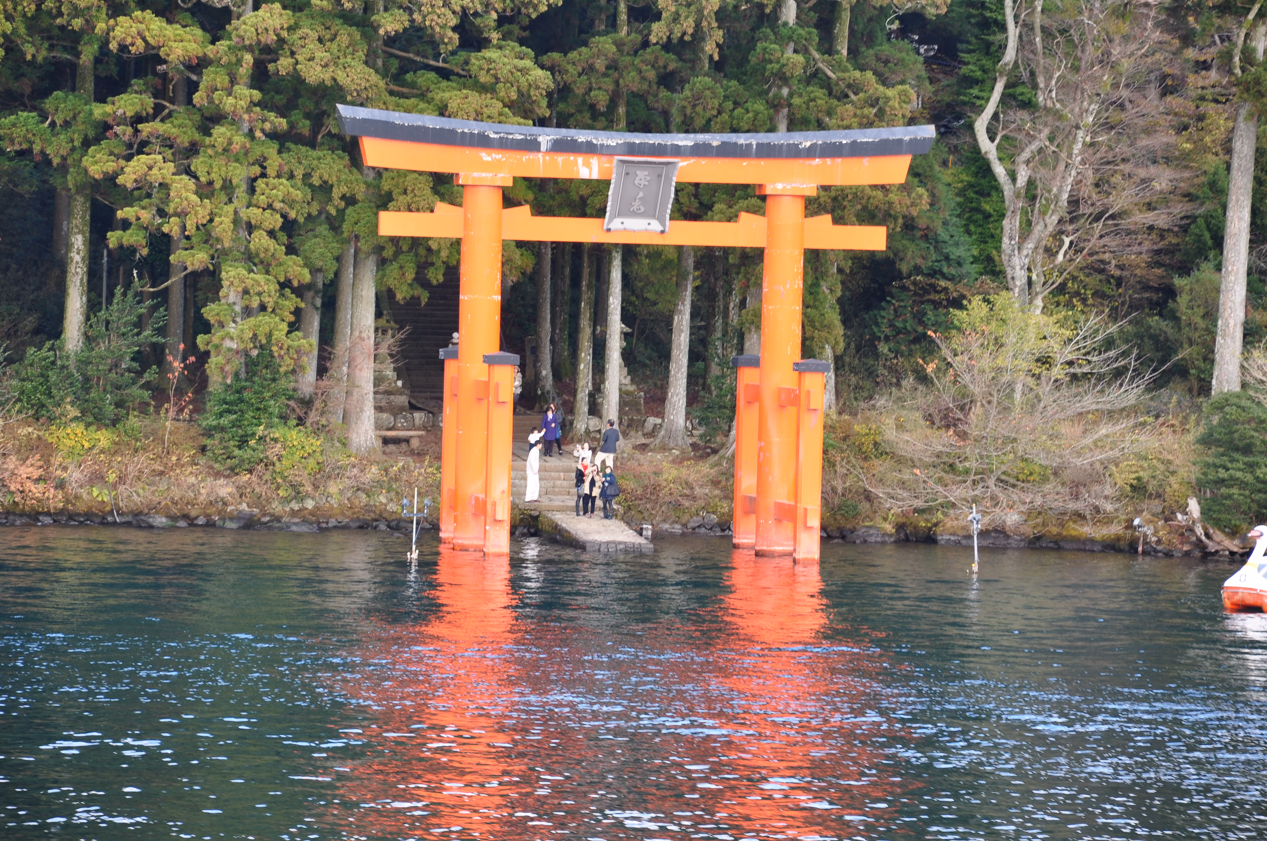 Straight-on view of the red torii gate standing in Lake Ashi