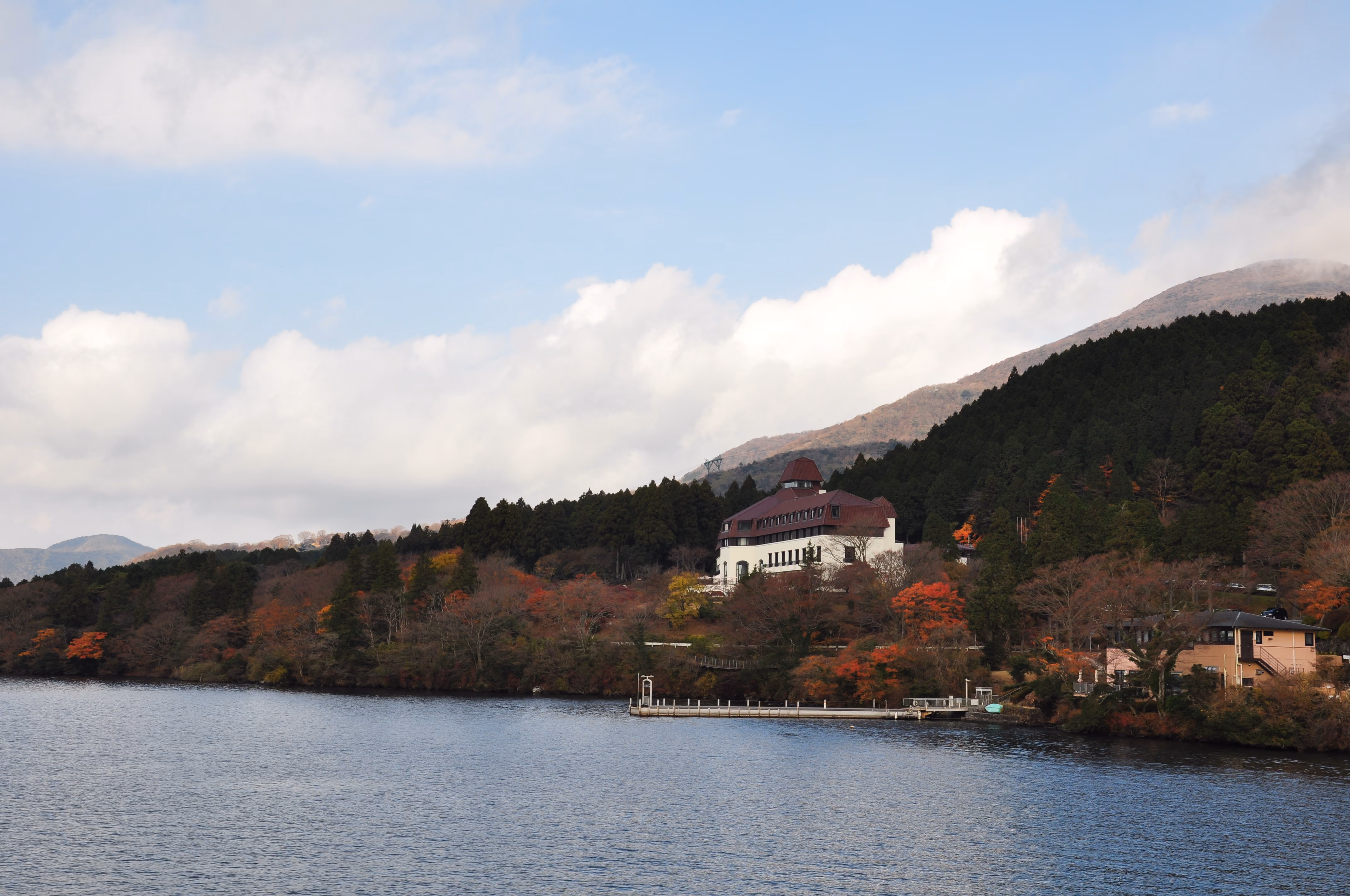 A lakeside hotel at Lake Ashi surrounded by autumn foliage