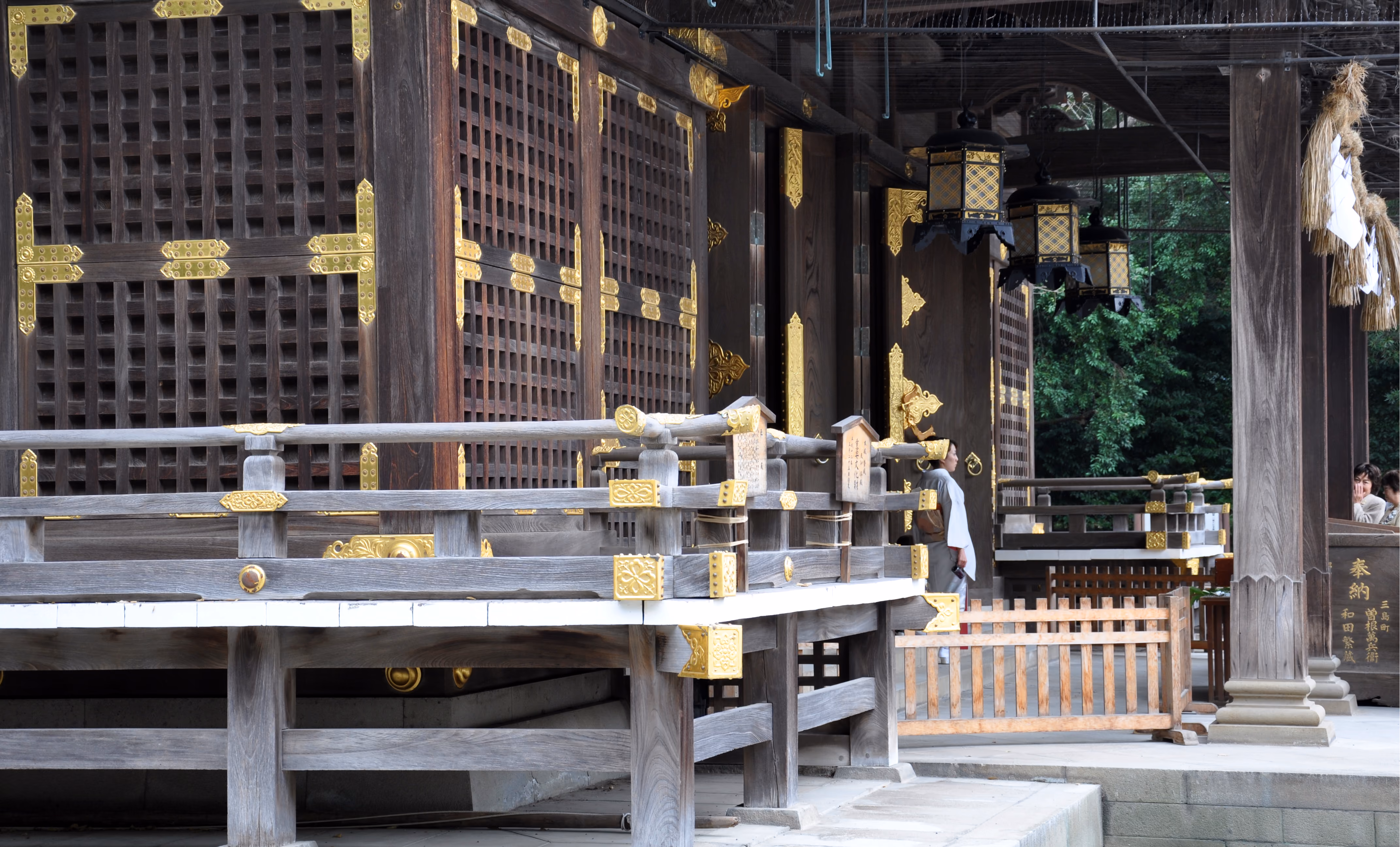 Porch of the offering hall at Mishima Taisha with gold-fitted railings and hanging lanterns