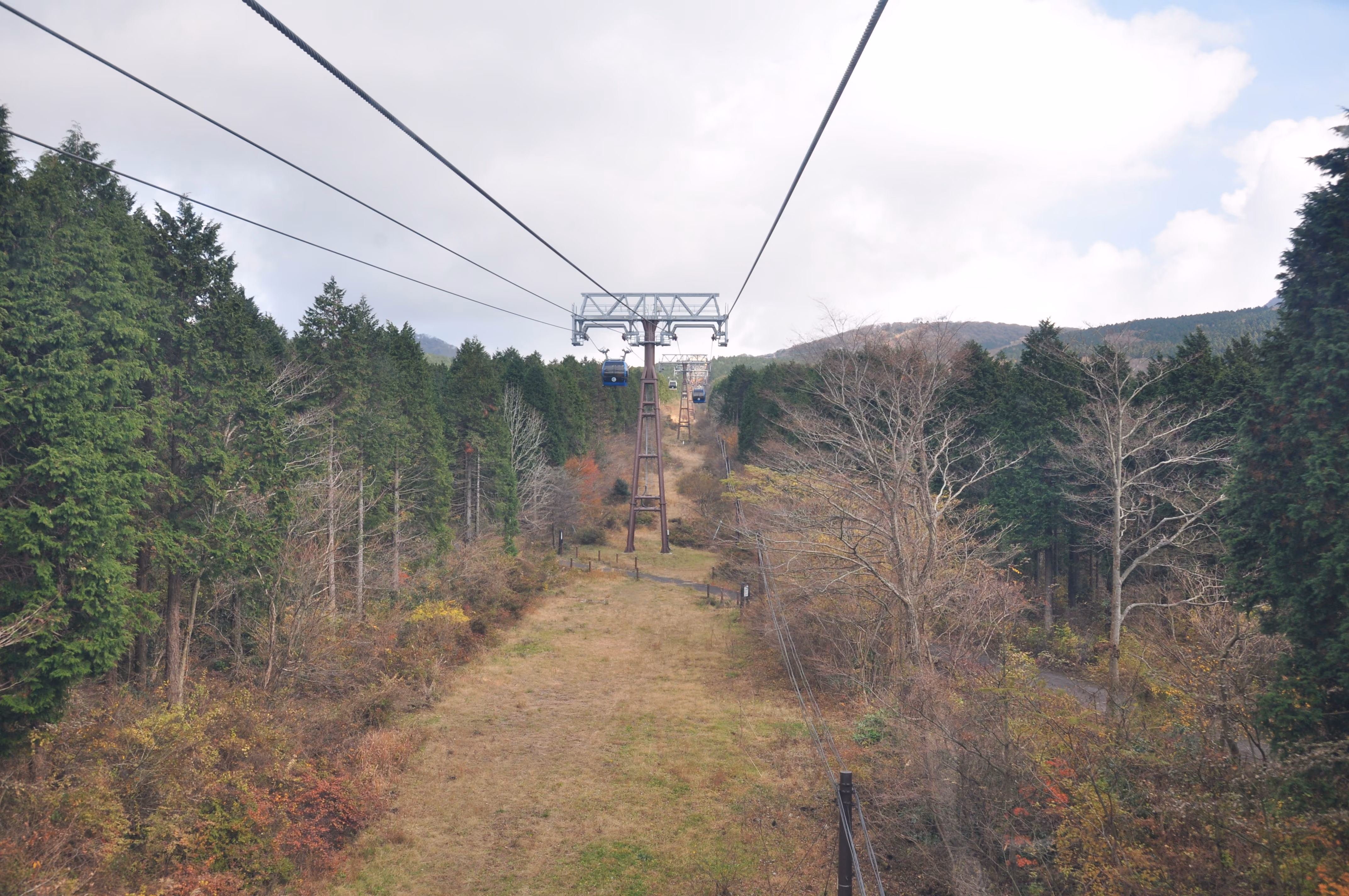 Hakone Ropeway gondolas descending toward a valley town visible below