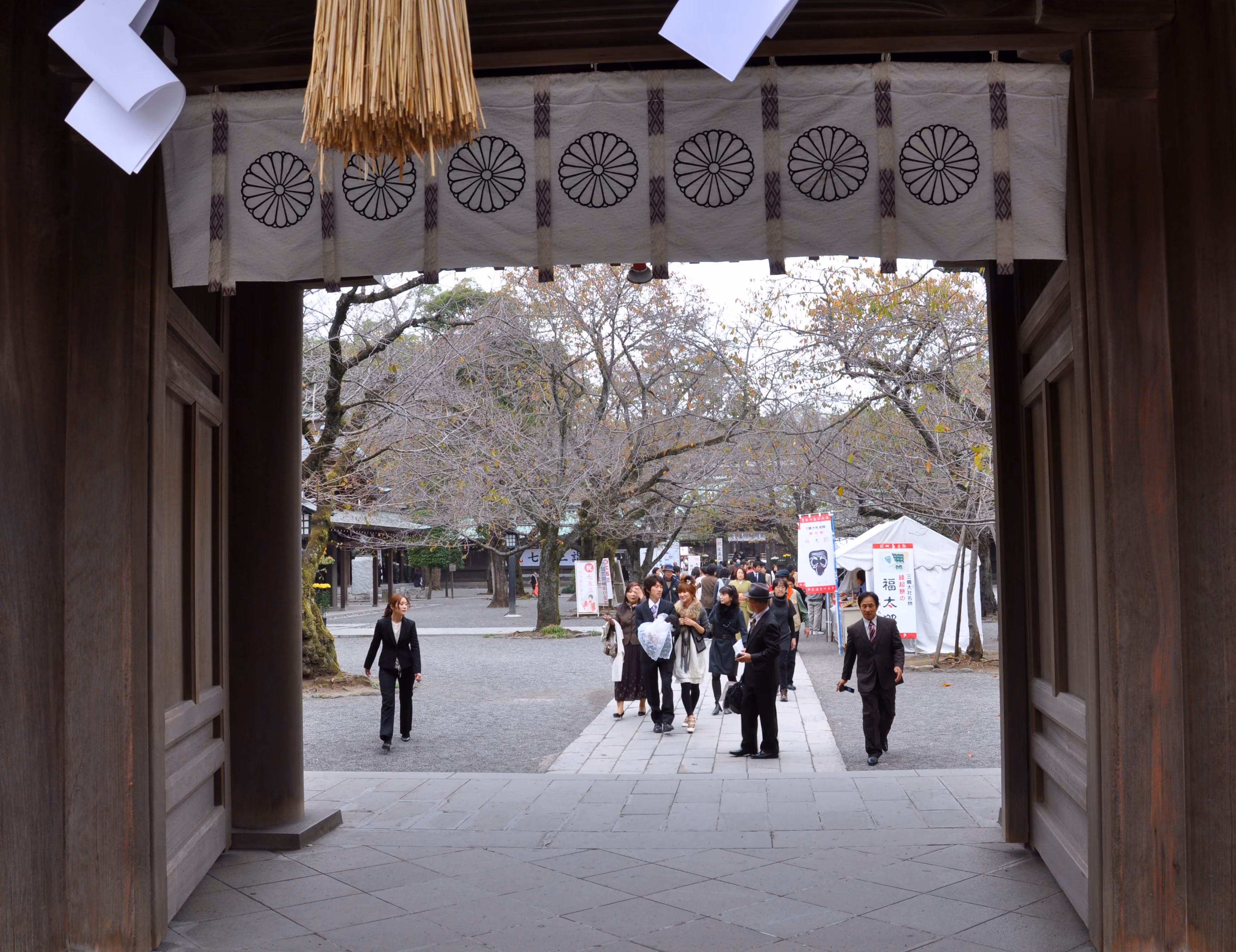 View looking outward through the Shinmon gate at Mishima Taisha, with a chrysanthemum-crest curtain overhead