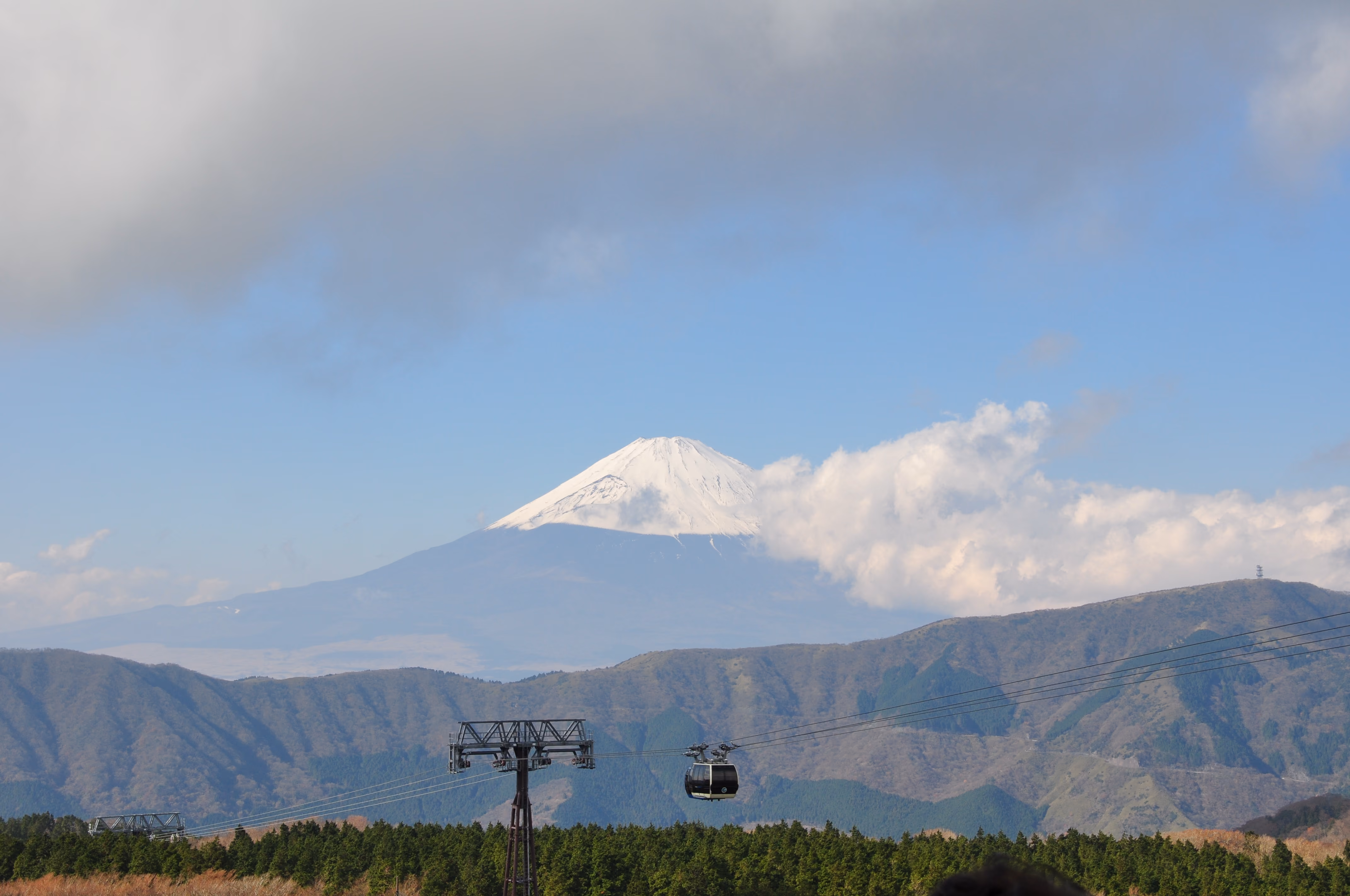 Mount Fuji seen from a Hakone Ropeway gondola, snow-capped against a blue sky