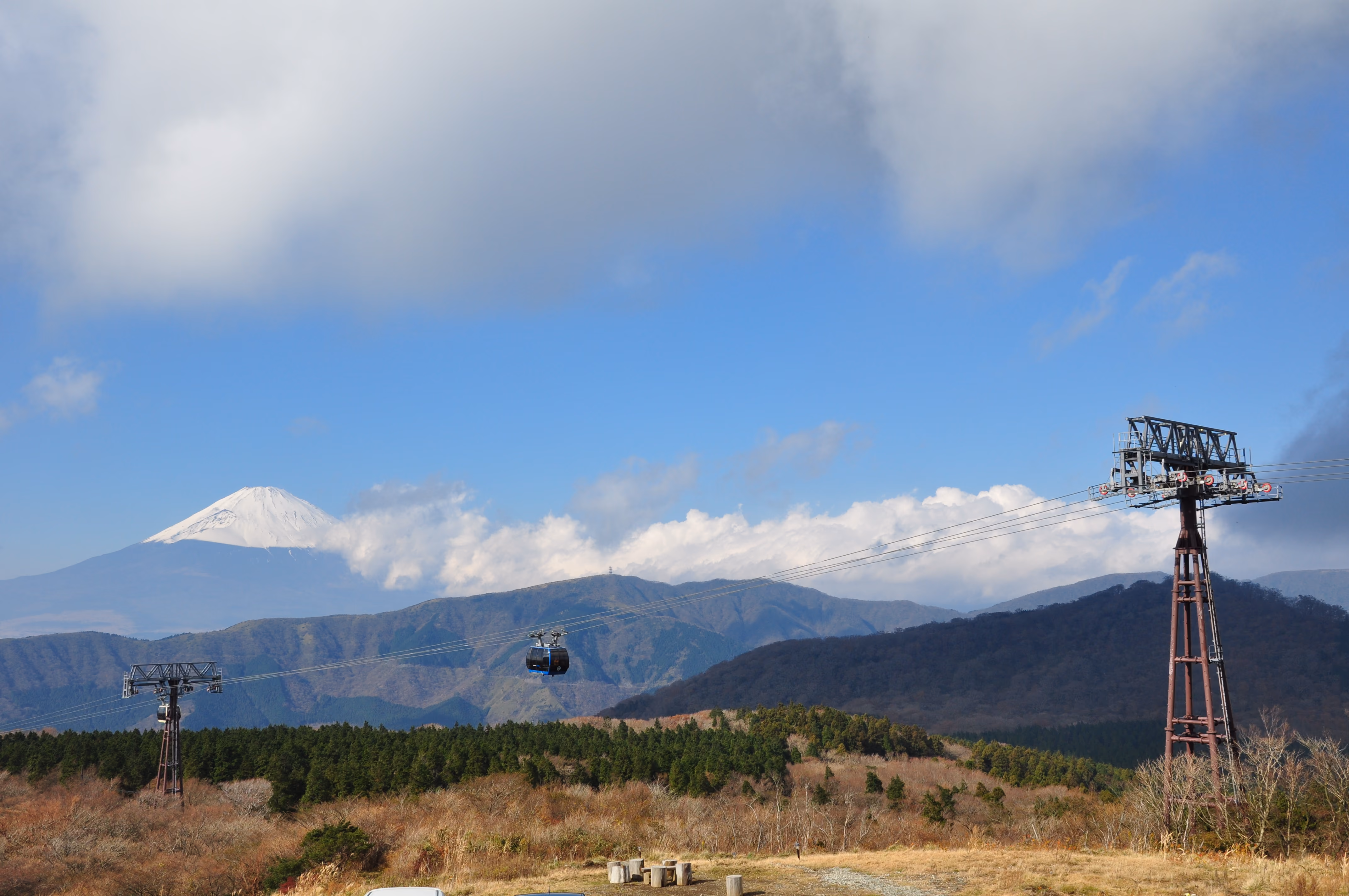 Two Hakone Ropeway gondolas crossing in front of Mount Fuji