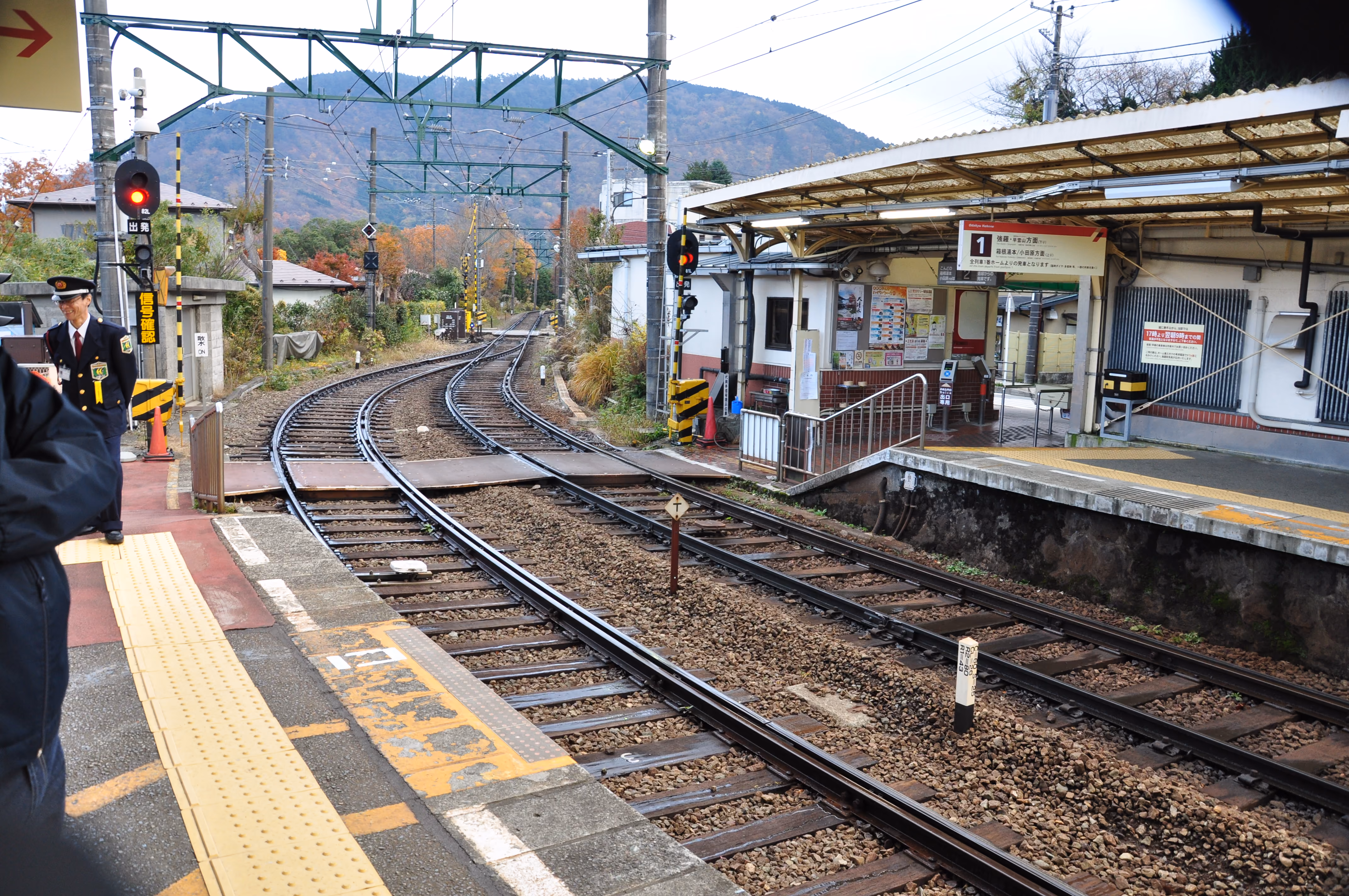 Gora Station platform and tracks, with a railway conductor standing on the platform