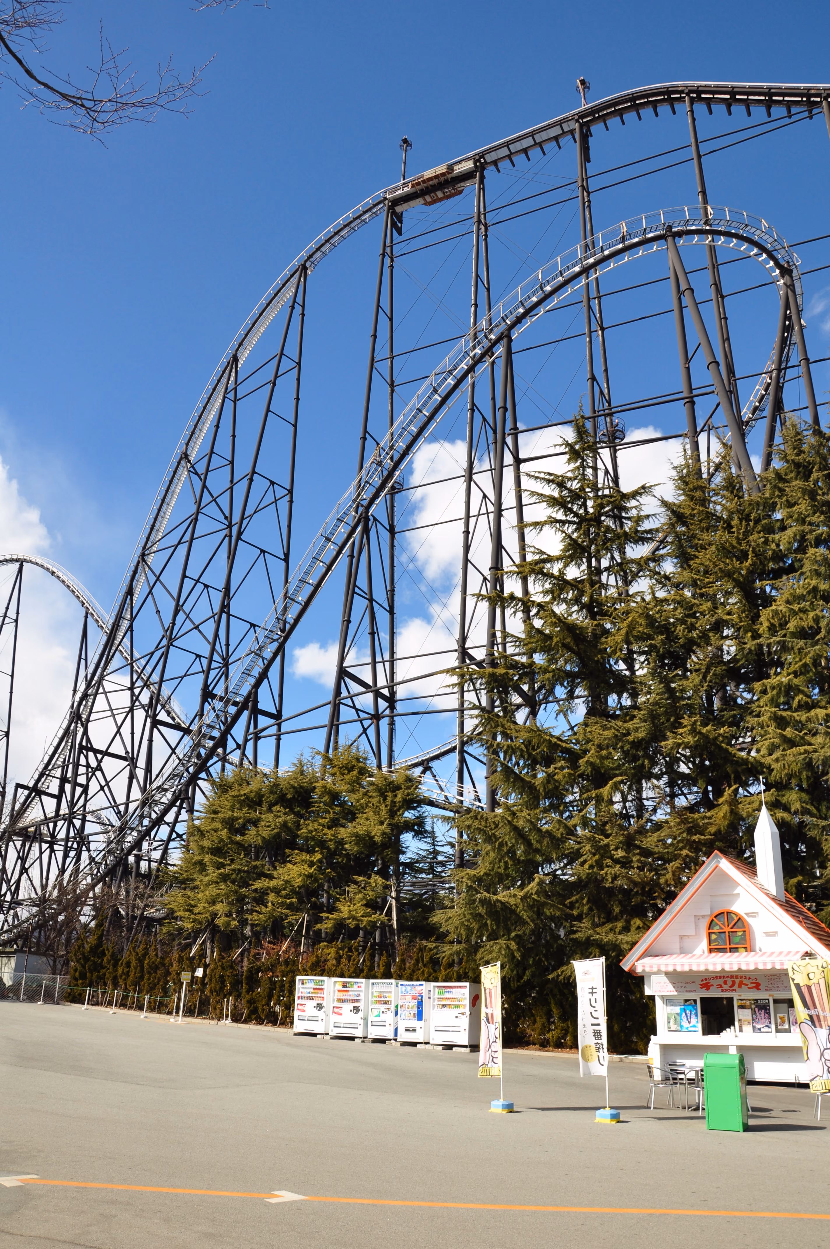 The steel structure of the Fujiyama roller coaster towering over trees and vending machines